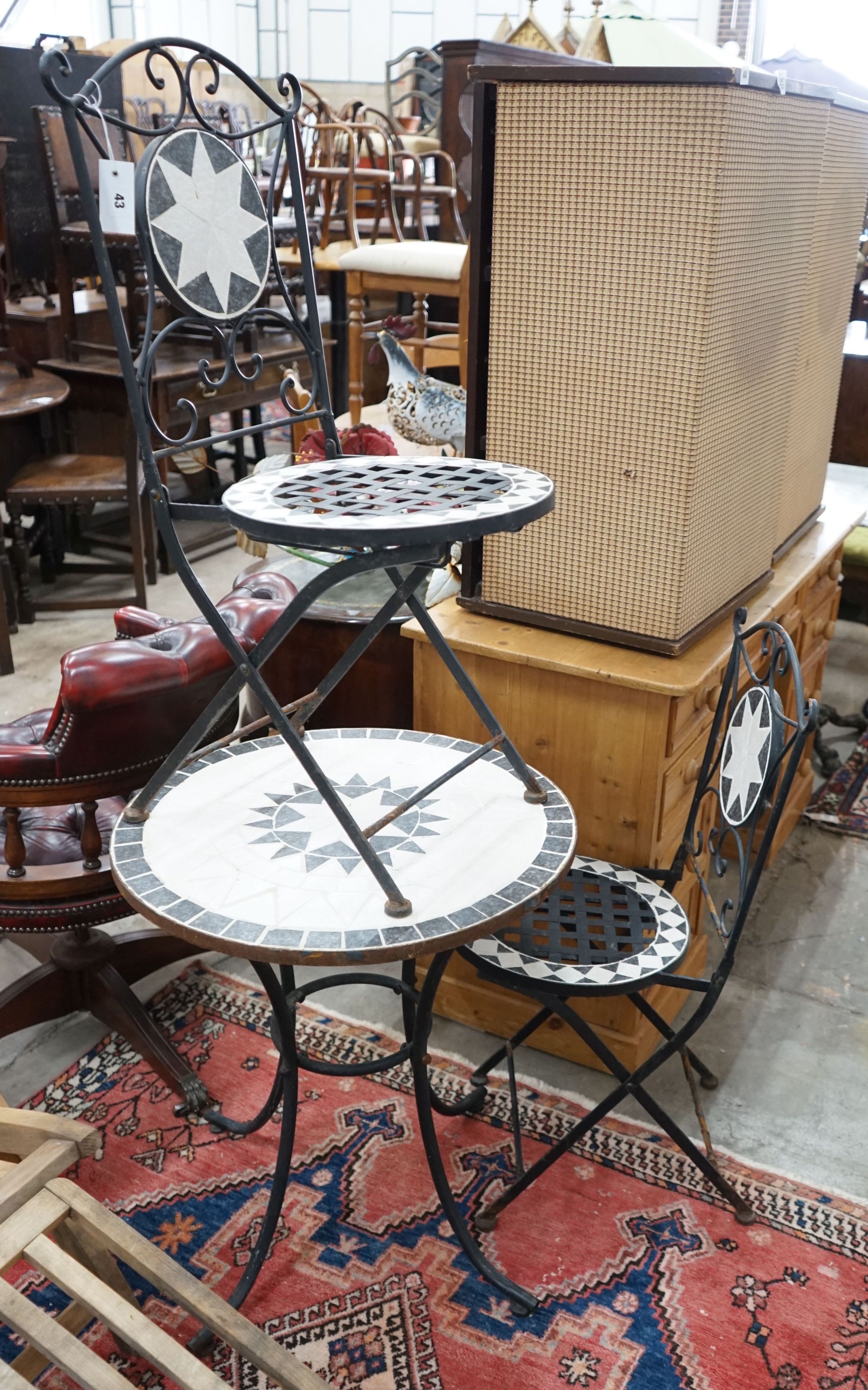 A wrought iron mosaic top circular bistro table, diameter 60cm, height 70cm together with a pair of folding chairs
